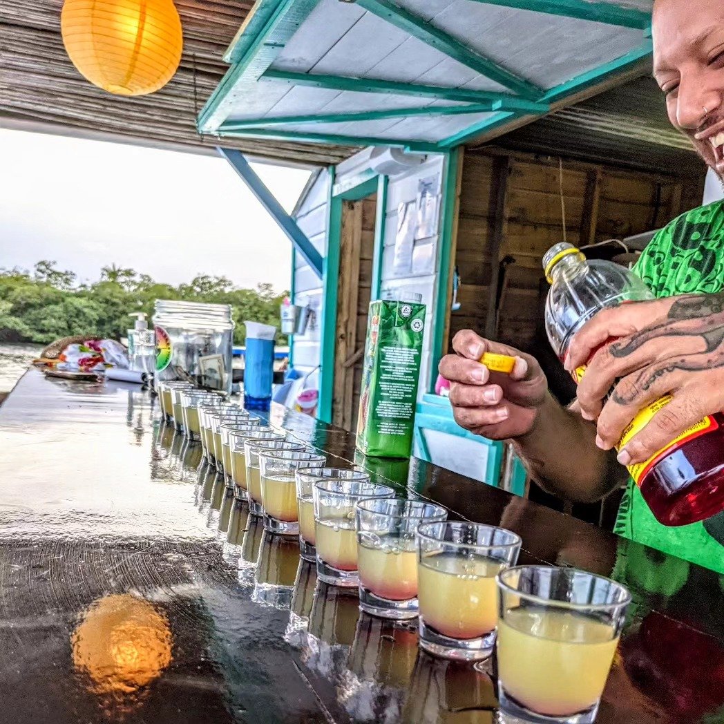 Bartender pouring a long lineup of shots along the bar for Tequila Thursday
